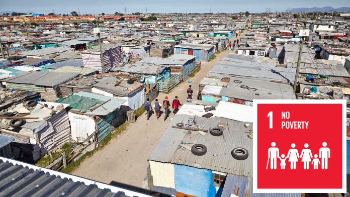 Children walk through a slum, next to this picture is the icon of SDG 1 "No poverty"