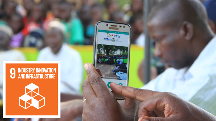 In the foreground mobile phone, with which the motif in the background - a group of people - is photographed.