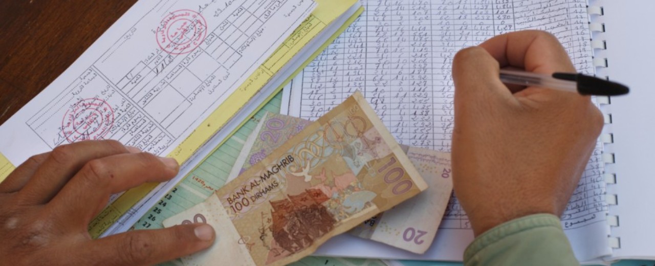 A men writing, money on the table.