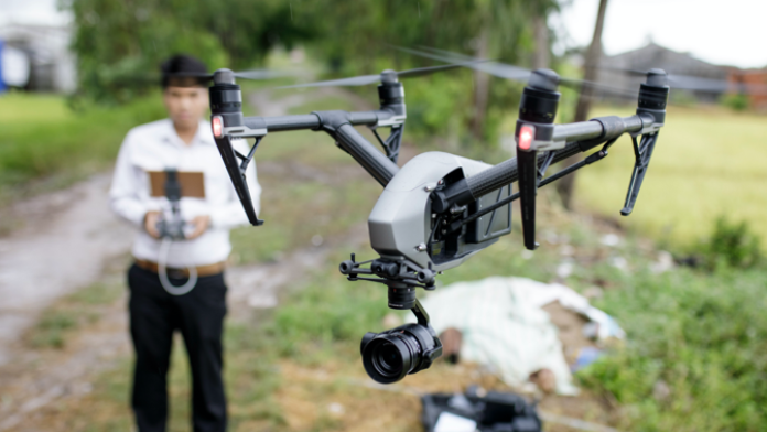 Man controlling a drone. Drone is in the foreground.