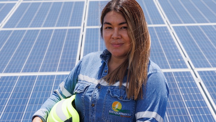 Female engineer standing in front of solar panels