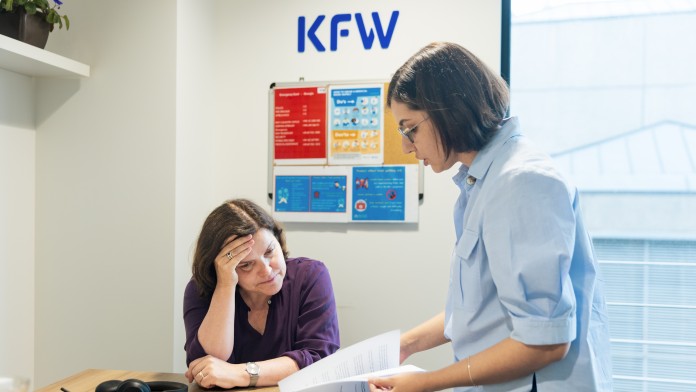 Two female KfW employees are engrossed in project documents