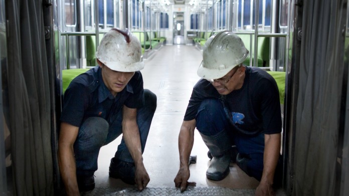 Worker maintaining a train in a railroad depot