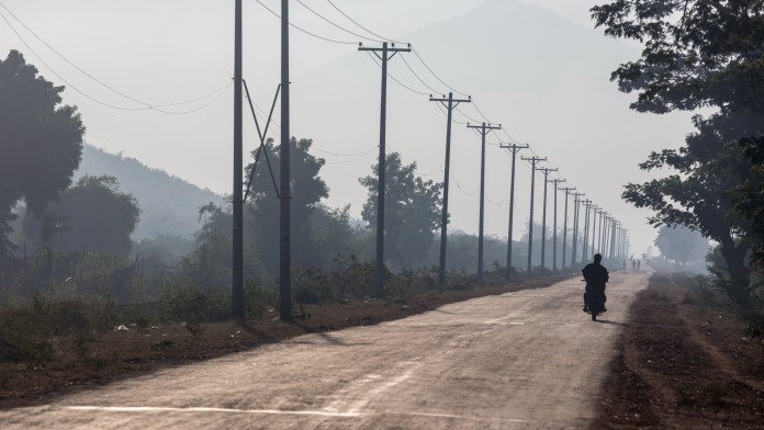 Einzelnes Motorrad auf der unbefestigten Straße zum Kinda Staudamm, Myanmar