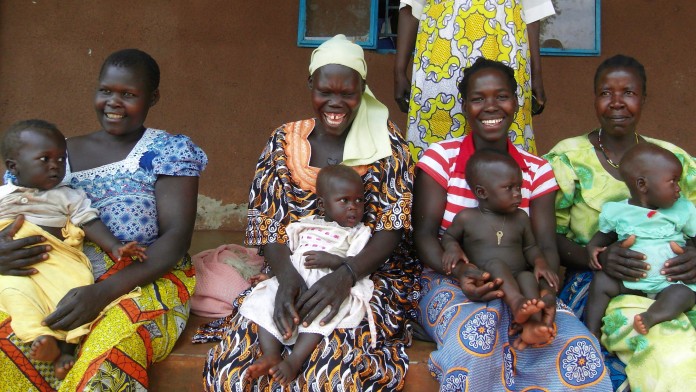 Women smiling into the camera infront of a health station